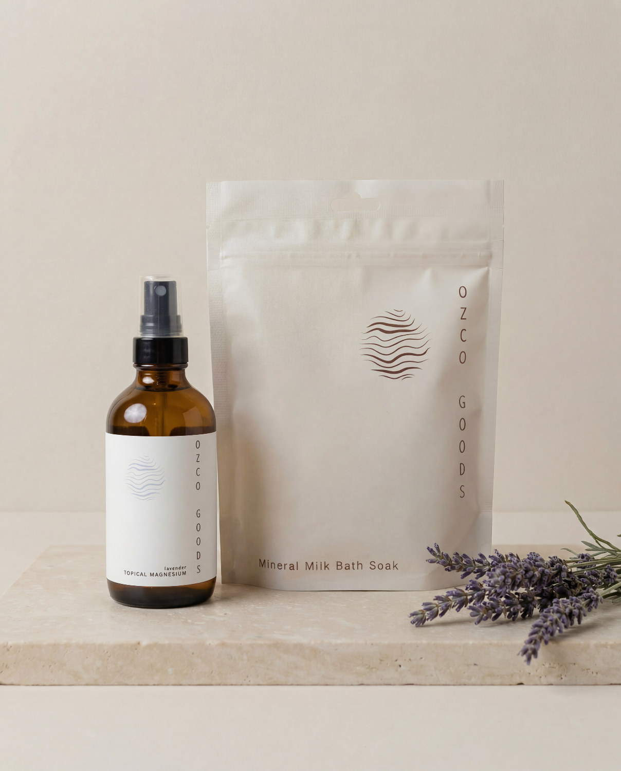 Ozco Goods lavender magnesium spray and bath soak on a neutral background with lavender.