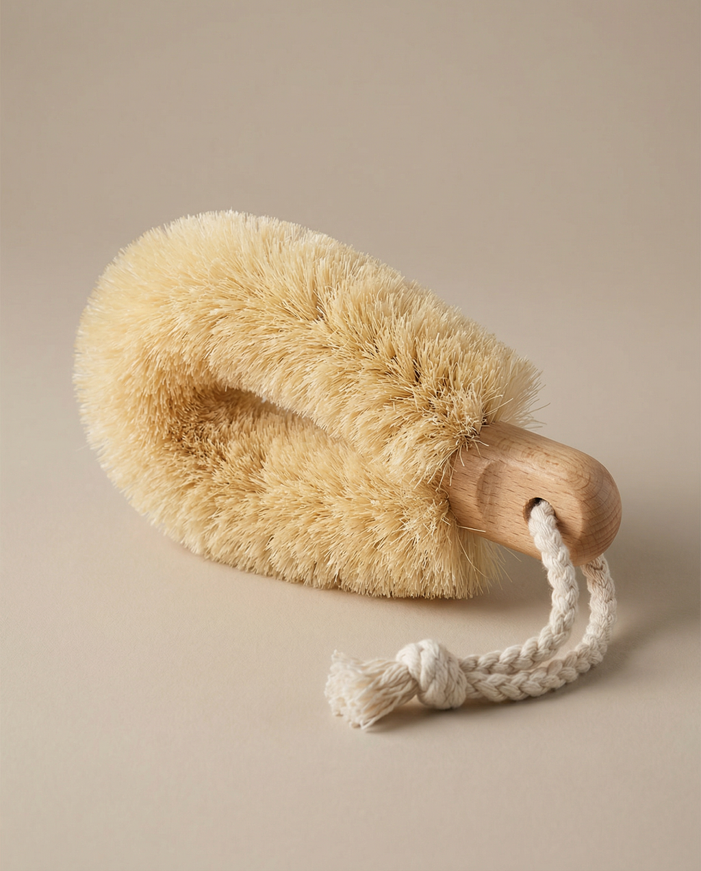 Body brush with wooden handle and natural bristles on a beige background
