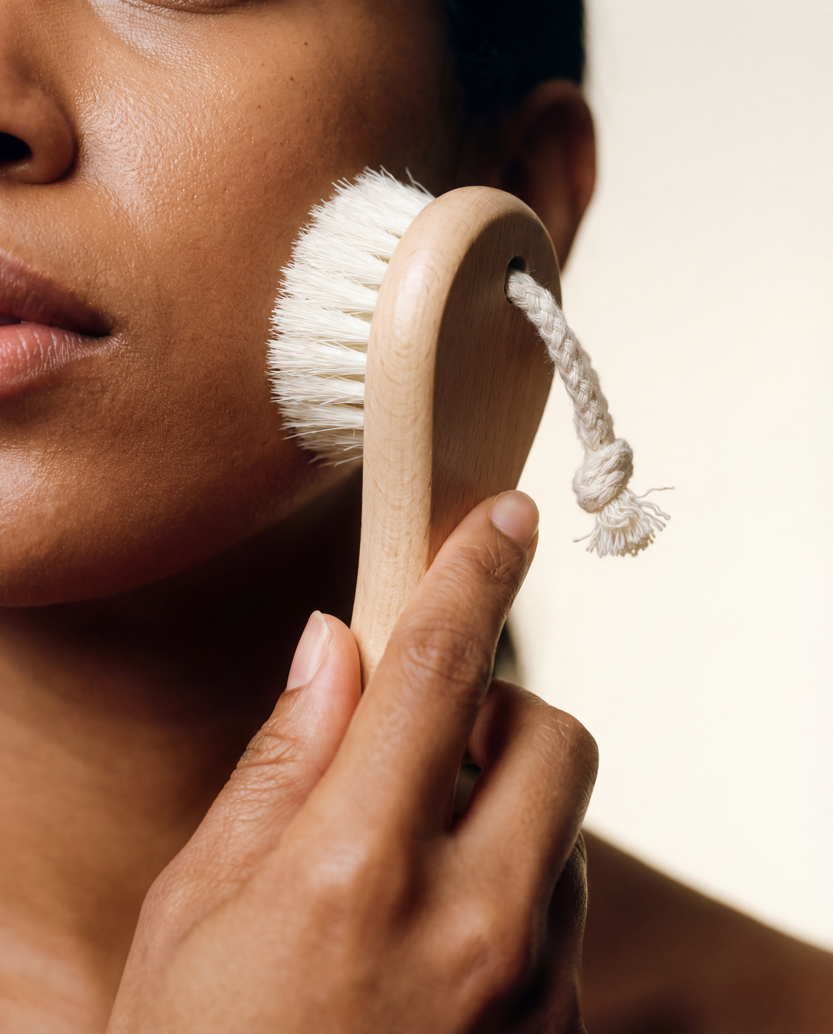 Woman using natural face brush against white background
