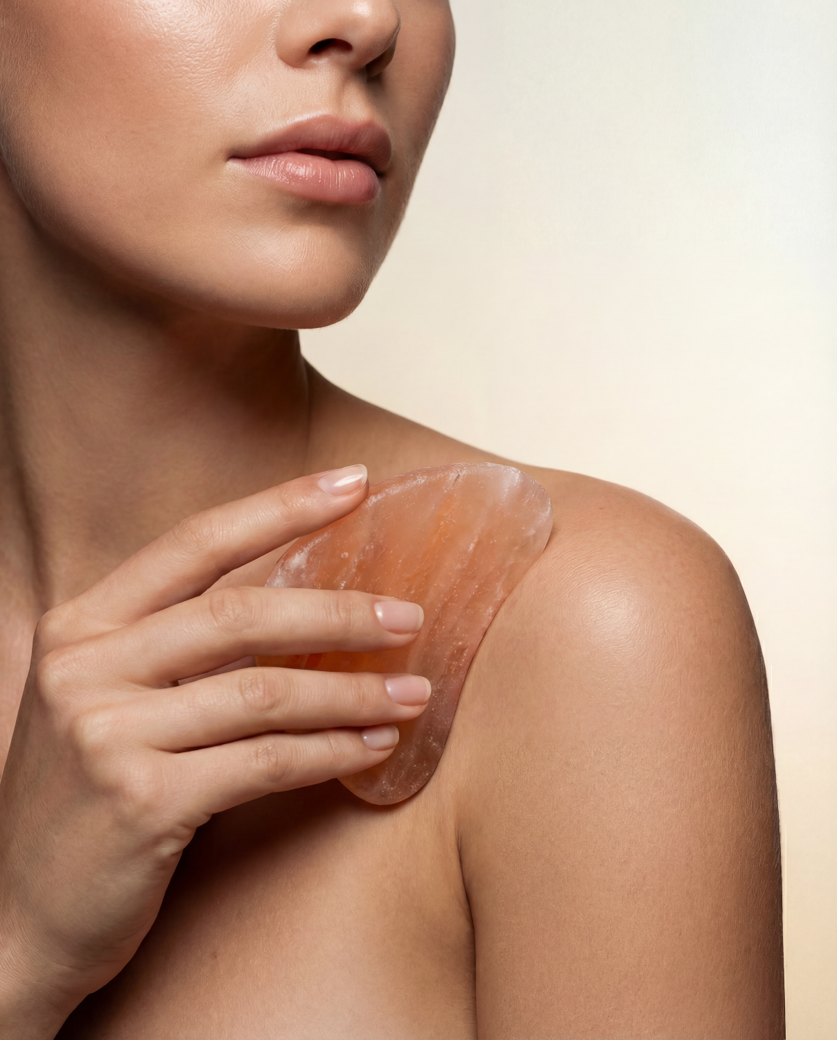 Woman using Himalayan Gua Sha Stone on body against white background