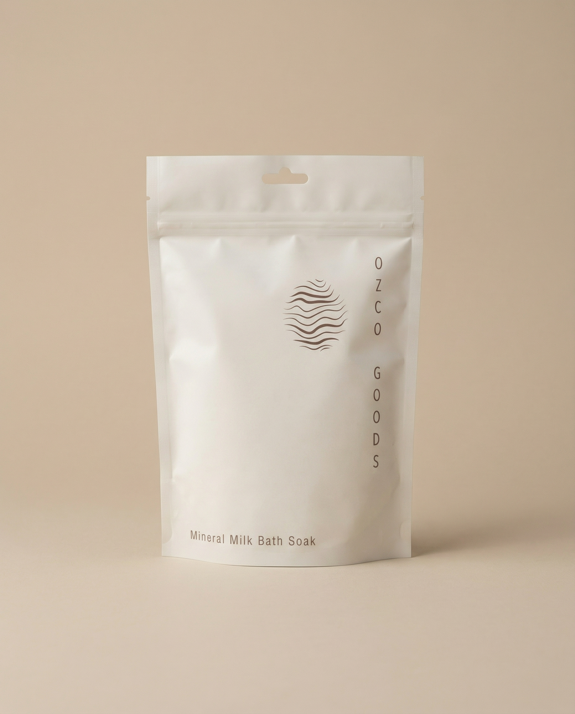White packaging of Ozco Goods Mineral Milk Bath Soak on a beige background