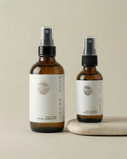 Two magnesium spray bottles with white labels on a beige background