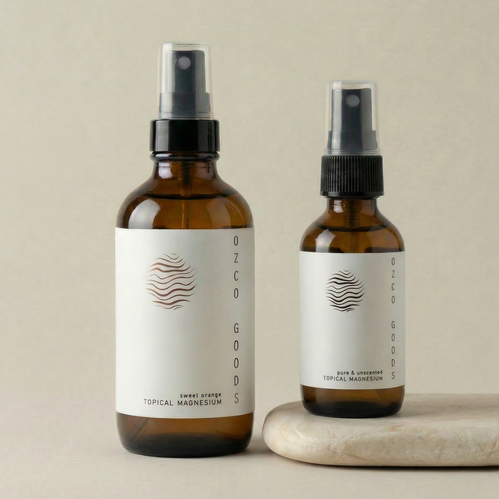 Two different sized magnesium spray bottles with white labels on a beige background